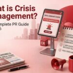 What is crisis management PR guide cover image showing a digital tablet, megaphone, newspaper, and coffee cup on a desk.